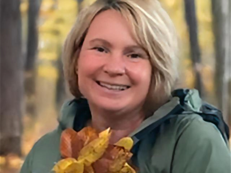 Bild von Ulrike mit grüner Jacke und buntem Tuch, sie lächelt