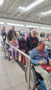 Urlaubsgruppe steht in Schlange beim Check-In am Flughafen Urlaubsgruppe steht in Schlange beim Check-In am Flughafen