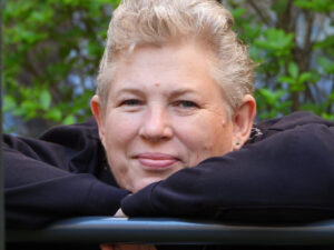 Monika Wegscheider, ca. 55 Jahre, lehnt sich an ein Geländer, kurze Haare